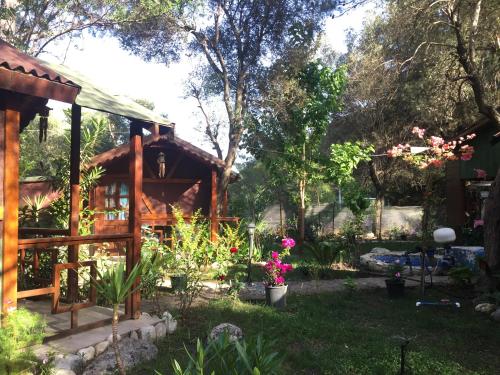 a garden in front of a cabin with flowers at Canario Bungalows in Cıralı