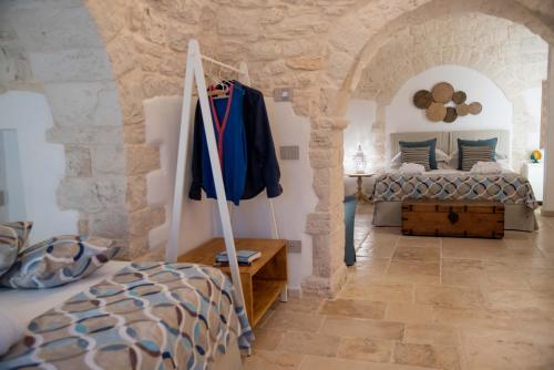 a bedroom with a bed in a stone wall at Chiancole - Trulli Experience in Alberobello