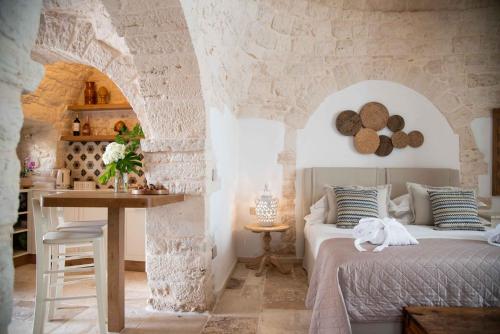 a bedroom with a bed and a table at Chiancole - Trulli Experience in Alberobello