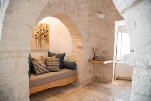 a room with a bench in a stone wall at Chiancole - Trulli Experience in Alberobello