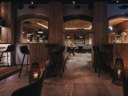 a bar with wooden columns and bar stools at VAYA Post Saalbach inklusive Joker Card in Saalbach Hinterglemm