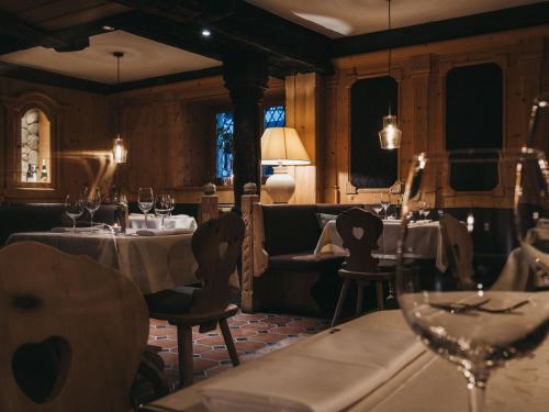 a restaurant with two tables with wine glasses on them at VAYA Post Saalbach inklusive Joker Card in Saalbach Hinterglemm