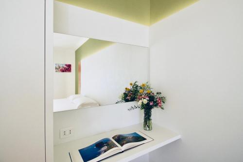 una habitación con un jarrón de flores en un estante en Olivò, en Bitritto
