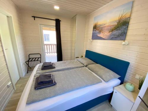 1 dormitorio con 1 cama grande y cabecero azul en Naturhaus Wassermann mit Boxspringbetten in ruhiger Lage, Meernähe, en Wunstorf