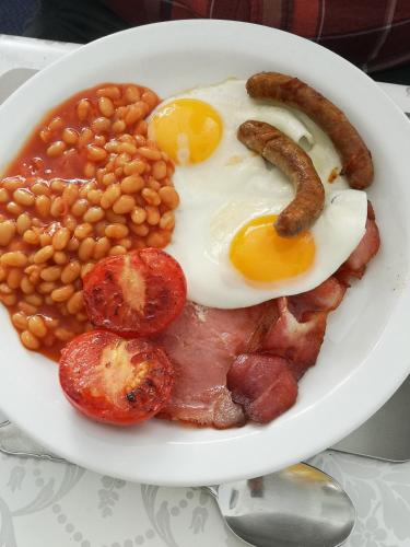 un piatto di prodotti per la colazione con uova in fagioli e salsicce di Blue Palms a Bournemouth