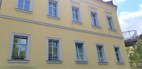 a yellow building with white windows on it at Villa Hoffnung in Bad Elster