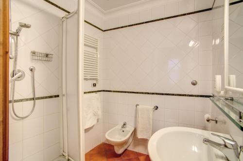 a white bathroom with a sink and a toilet at PRIMAVERA GH in Rome