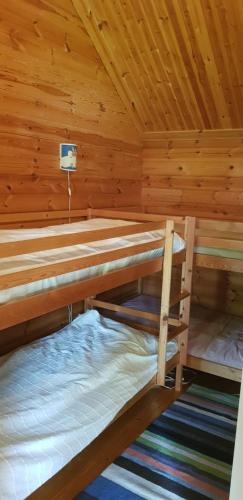 a bedroom with two bunk beds in a wooden cabin at Lill Hagahus, Söderåsens Nationalpark in Kågeröd