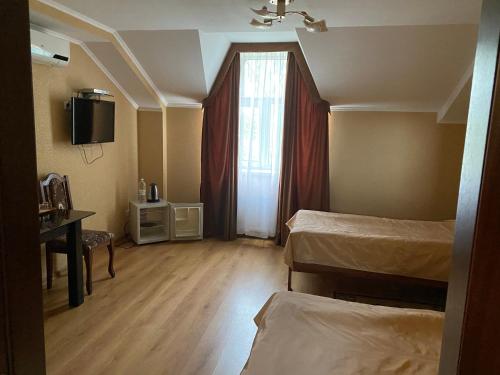um pequeno quarto com 2 camas e uma janela em Гостинний маєток em Myla