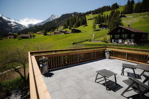 Un patio con una mesa y sillas en un balcón. en Bodehüttli, en Adelboden