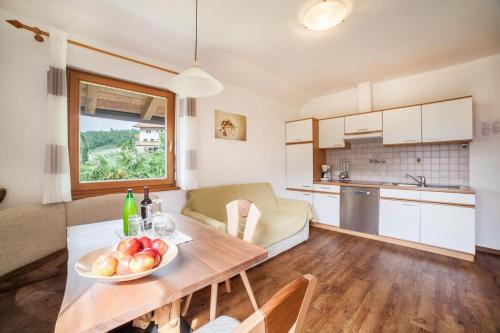 a kitchen and living room with a table with a bowl of fruit at Langeshof Fewo Abendrot in Caines