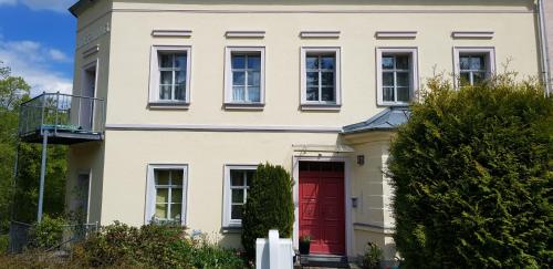 a white house with a red door at Villa Hoffnung in Bad Elster