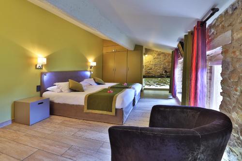 - une chambre avec un grand lit et une chaise dans l'établissement Logis auberge restaurant Du Vigneron, à Cucugnan