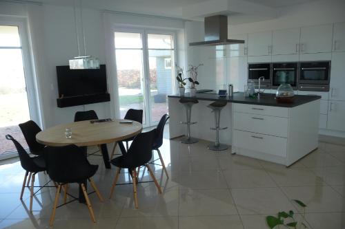 eine Küche mit einem Tisch und Stühlen sowie einem TV in der Unterkunft Værelse i Augustenborg i stor villa in Augustenborg