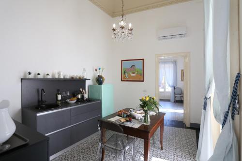 una cucina con tavolo e una sala da pranzo di Palazzo d'Autore - Luxury Home - Ragusa Centro a Ragusa