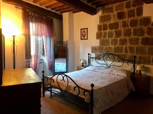a bedroom with a bed and a brick wall at Casa Vacanze Il Torchio in Piancastagnaio
