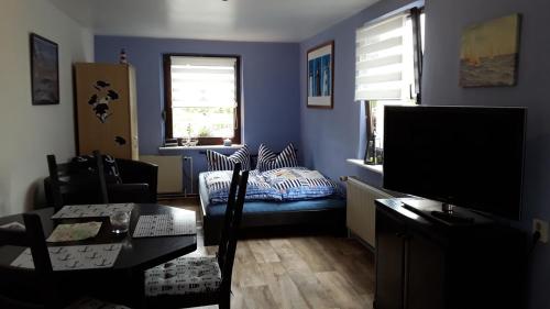 a blue living room with a couch and a tv at Ferienwohnung Putbus in Putbus