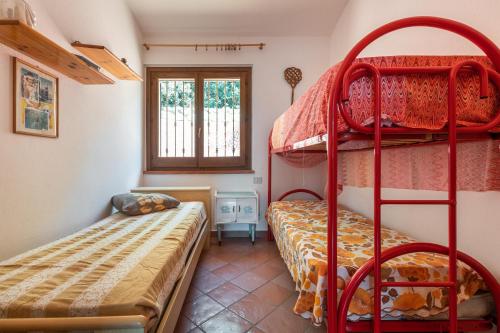 sypialnia z dwoma łóżkami piętrowymi i oknem w obiekcie Villa Gianna w mieście Torre delle Stelle