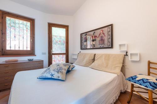 a bedroom with a white bed and a chair at Villa Gianna in Torre delle Stelle