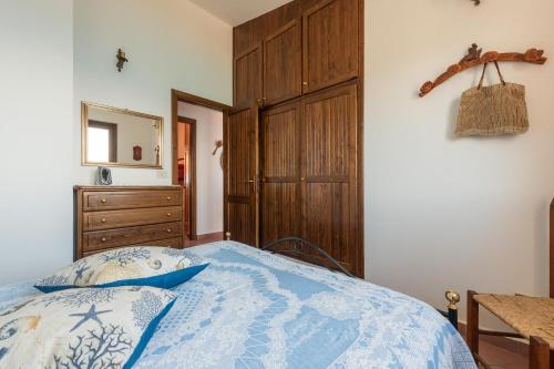 a bedroom with a bed and a wooden cabinet at Villa Gianna in Torre delle Stelle