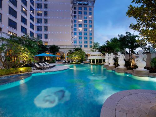 a large swimming pool in a city at night at Sofitel Macau At Ponte 16 in Macau