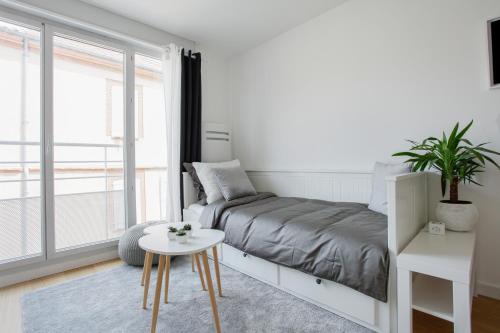 une chambre blanche avec un lit et une table dans l'établissement Le Platine, à Toulouse