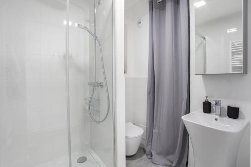 une salle de bain blanche avec douche et toilettes dans l'établissement Le Platine, à Toulouse