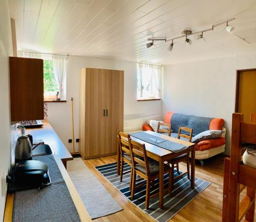 ein Wohnzimmer mit einem Tisch und einem Sofa in der Unterkunft Apartmány v ráji (Českém) in Blata