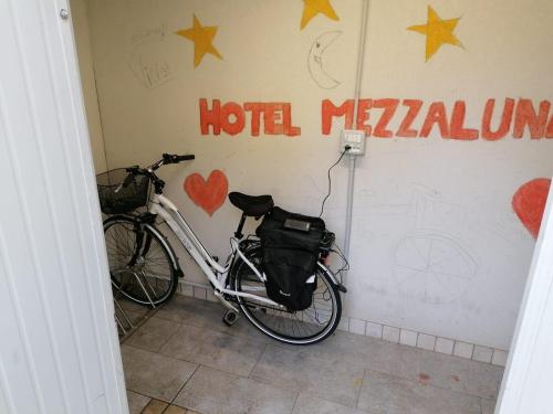 a bike parked against a wall with a hotelulum sign at Hotel Mezzaluna in Treviso