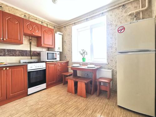 a kitchen with wooden cabinets and a white refrigerator at Kakadu apartments in Sumy