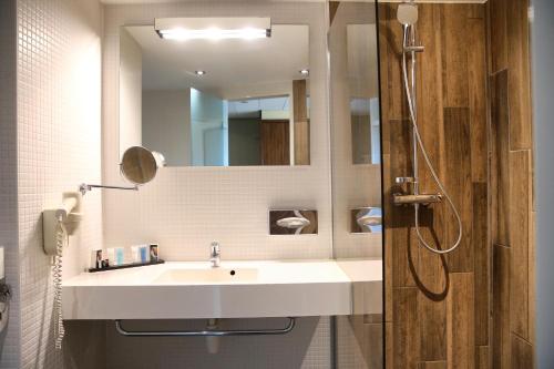a bathroom with a sink and a mirror at Van der Valk Hotel Rotterdam - Blijdorp in Rotterdam