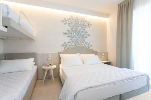 a bedroom with two beds and a staircase at Hotel Mirafiori in Lido di Jesolo