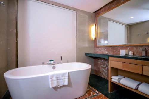 a bathroom with a large tub and a mirror at Welcomhotel by ITC Hotels, Jodhpur in Jodhpur