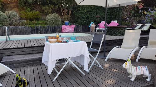a table and chairs on a deck with an umbrella at la VILLA GUIDI in Pila-Canale