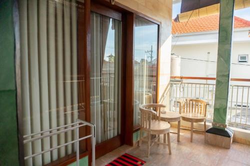 a balcony with sliding glass doors and a table and chairs at Ika Homestay in Canggu