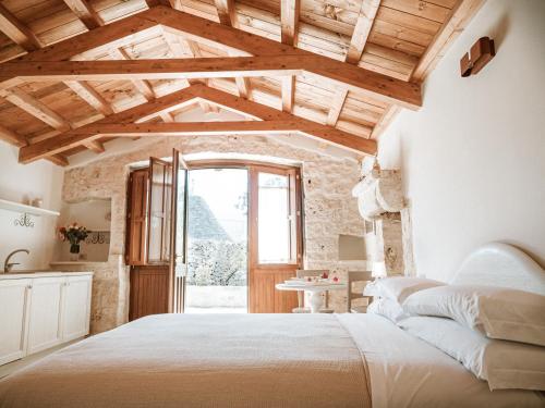 sypialnia z dużym łóżkiem i oknem w obiekcie Rifugio di Puglia - Trulli & Dimore w Alberobello