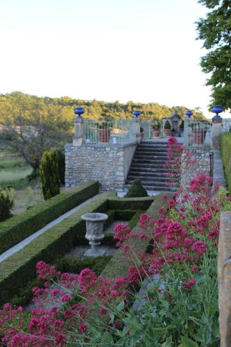 a garden with pink flowers and a stone staircase at Château du Grand Jardin in Valensole