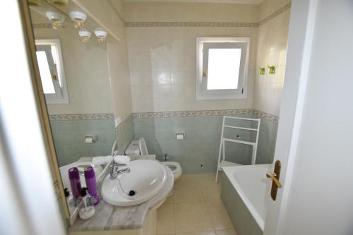a bathroom with a sink and a toilet and a tub at Villa La Buena Vida in Benissa