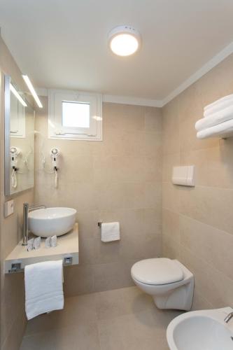 a bathroom with a white toilet and a sink at Hotel Mirafiori in Lido di Jesolo
