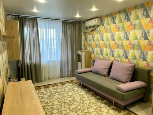 a living room with a couch and a table at Квартира с раздельными комнатами, левый берег, пр Правды, Ул Калиновая in Dnipro