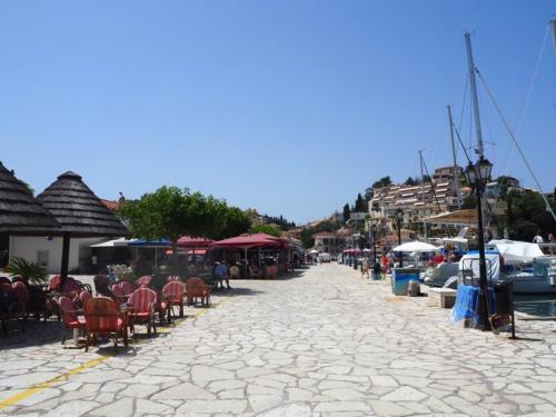 a cobblestone street with tables and chairs and boats at Sivotahomes-blu in Syvota