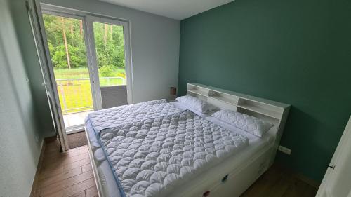 a bedroom with a white bed with a window at Seenadel in Gelbensande