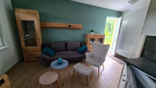 a living room with a couch and chairs and a table at Seenadel in Gelbensande