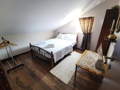 a bedroom with a white bed and a wooden floor at Villa Sofia in Kotor