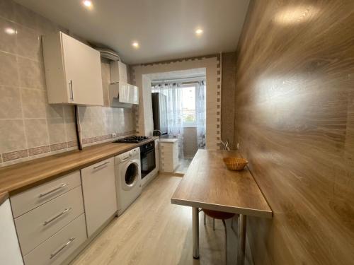 a kitchen with a wooden counter top in a room at Квартира с раздельными комнатами, левый берег, пр Правды, Ул Калиновая in Dnipro