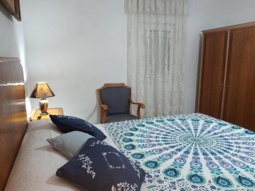 a bedroom with a bed with a blue and white quilt at Casa de Pascual in Yecla