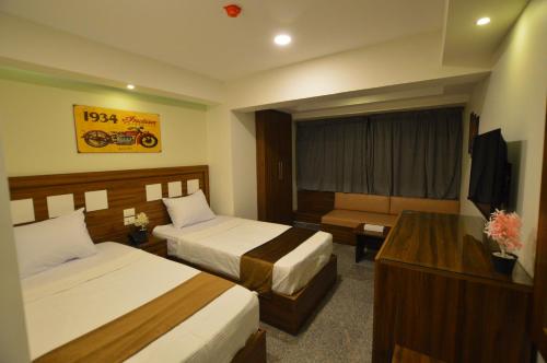 een hotelkamer met 2 bedden en een bureau bij Royal Inn Residence in Caïro