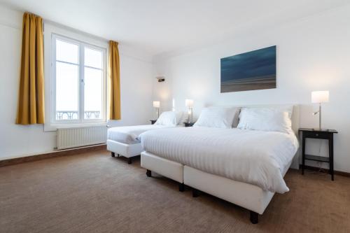 a bedroom with two beds and a window at Thermae Palace in Ostend