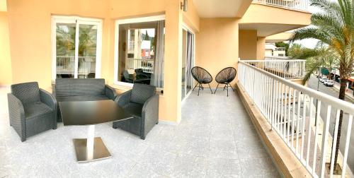 a balcony with chairs and tables on a building at Apartamentos Las Palmeras in Palmanova