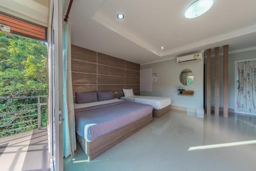 a bedroom with two beds and a balcony at Tachang Airport Hotel in Hat Yai